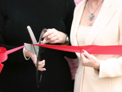 cutting ribbon at a grand opening event